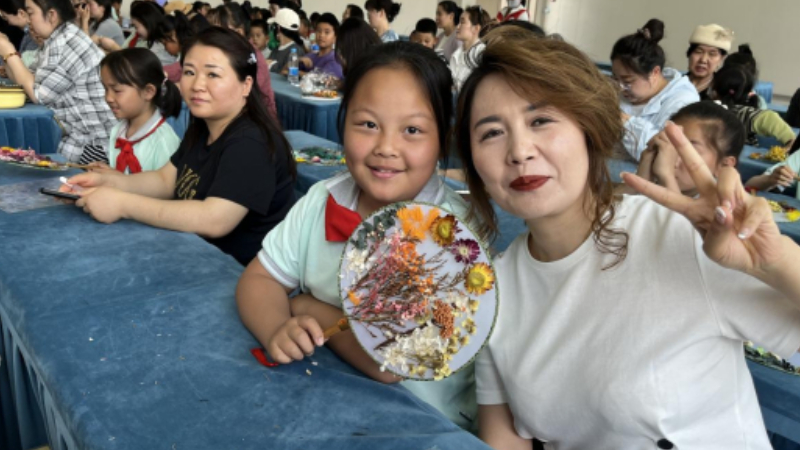 吴忠市利通区材机社区：非遗团扇寄深情，亲子手作颂母恩