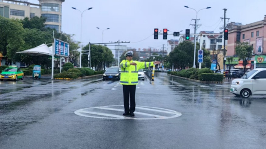 暴雨街头讲交规 荧光黄守护出行路