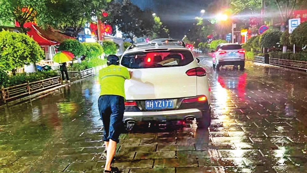 多辆小型轿车被困 三名执勤辅警推车救援