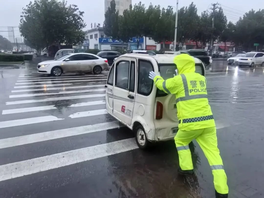 河南商丘交警雨中坚守“高峰护学岗” 荧光黄演绎别样风“警”