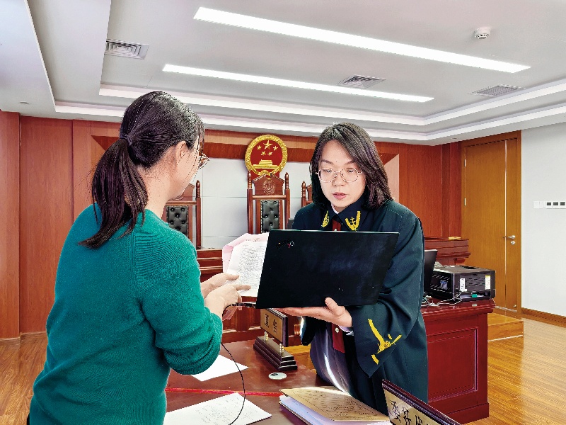 法官陈聪慧(右)正在和原告沟通案情(北京市海淀区人民法院 供图)_副本.jpg