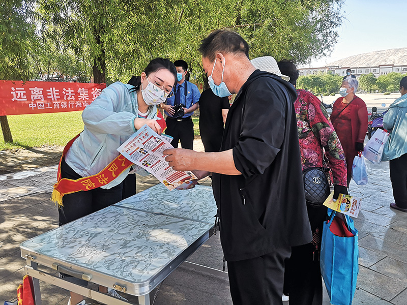 2022年7月6日,法官高贝贝来到海南广场开展普法宣传活动。图为高贝贝正在为群众发放宣传册。(刘瑞雪 摄).jpg