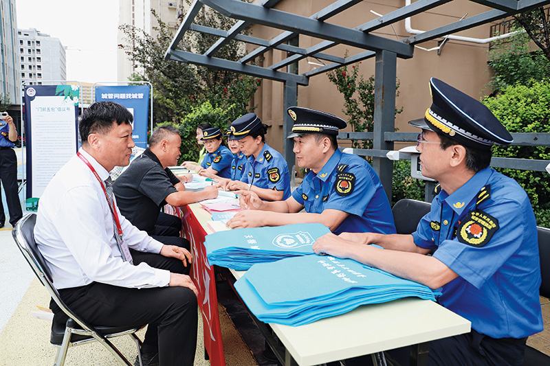 图4(第3标题配图济南市天桥区城管局法制科科长许平(右二)正在耐心解答涉企政策咨询)摄影 韩飞燕.jpg