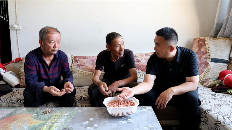 村民覃忠立(中)对现在生活很是满意。_proc.jpg