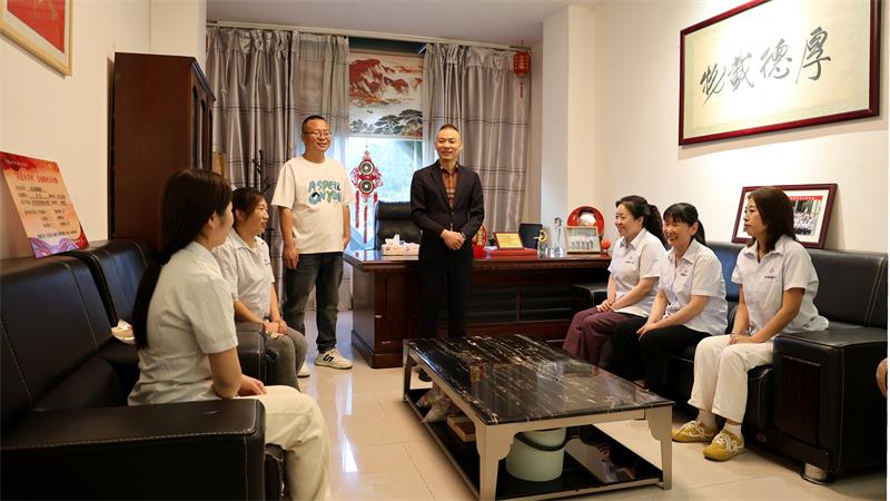 李战(中)正在向超市员工了解销售情况。_proc.jpg