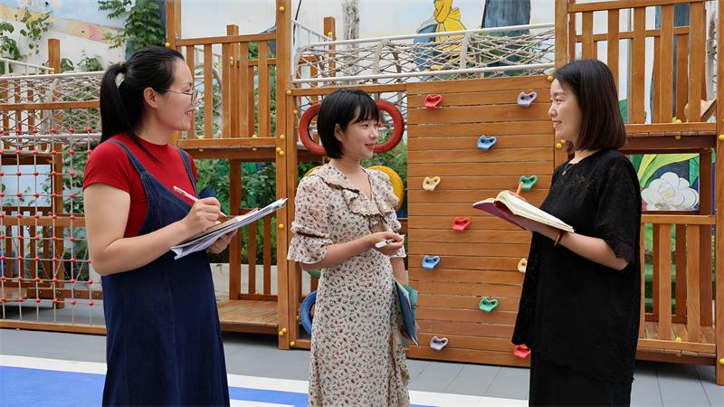 范灵芝(中)正和老师们商讨托幼工作_proc.jpg