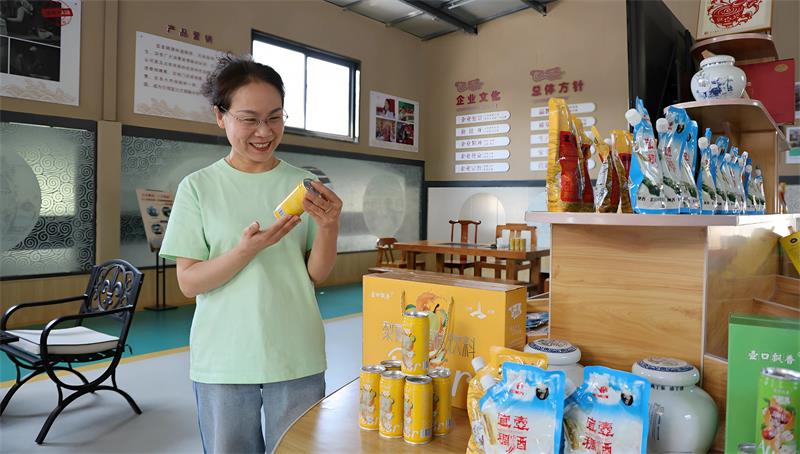 刘金玉正在查看“壶口飘香”稠酒果汁饮料外包装品质。_proc.jpg