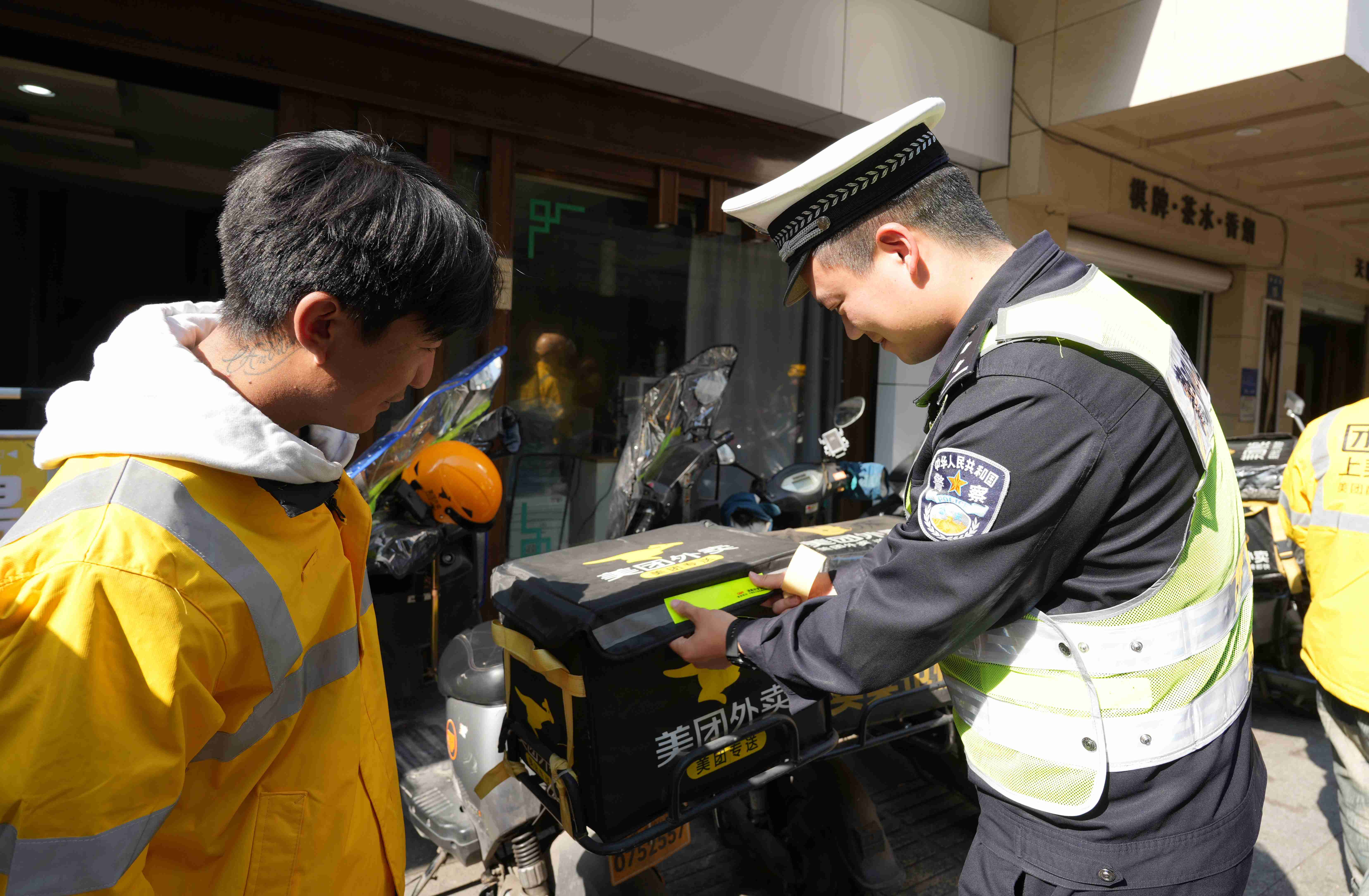 图为兰溪交警给外卖小哥的电动车上粘贴反光条.jpg