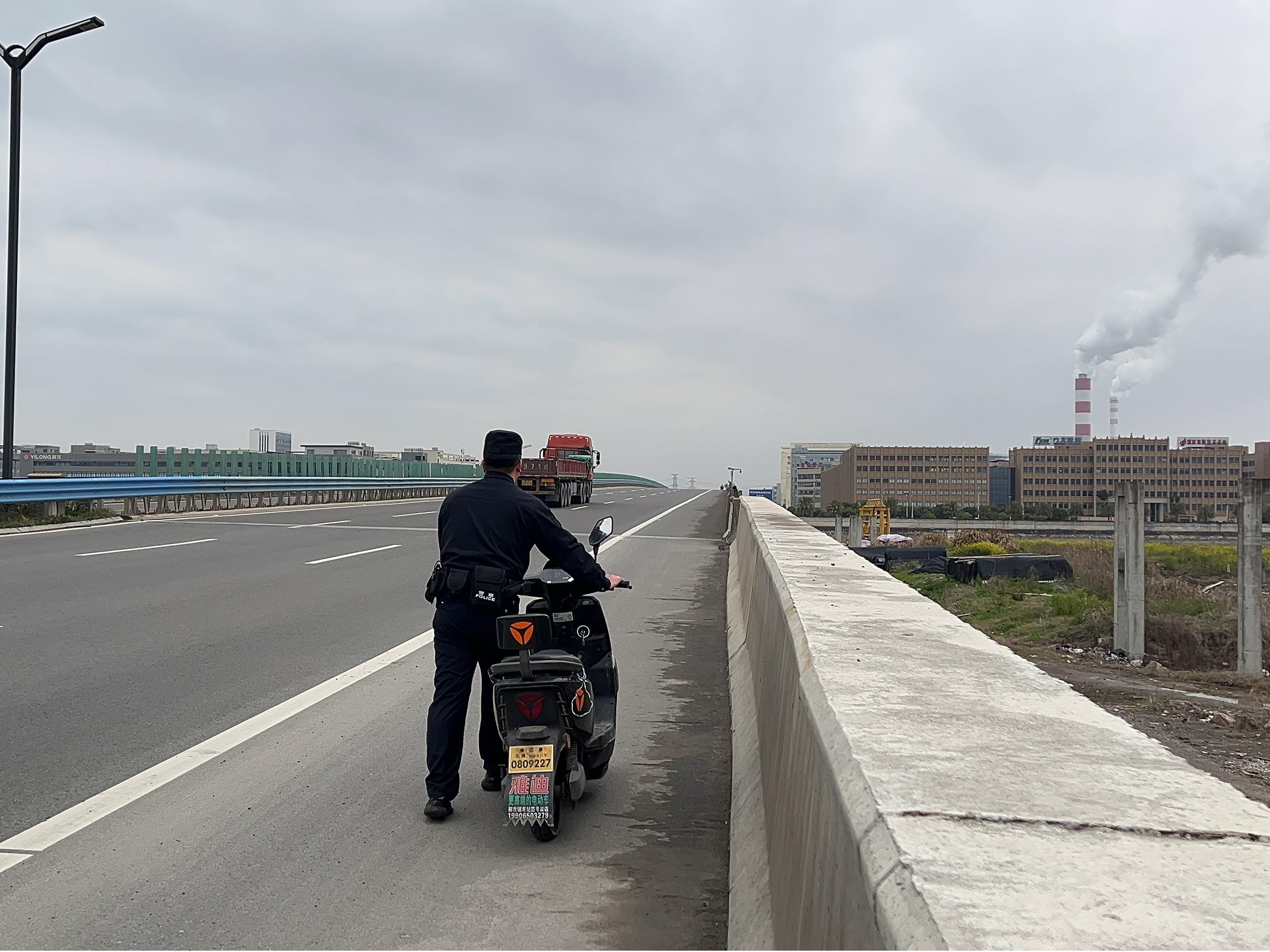 民警将电瓶车推往企业.jpg 民警将电瓶车推往企业.jpg