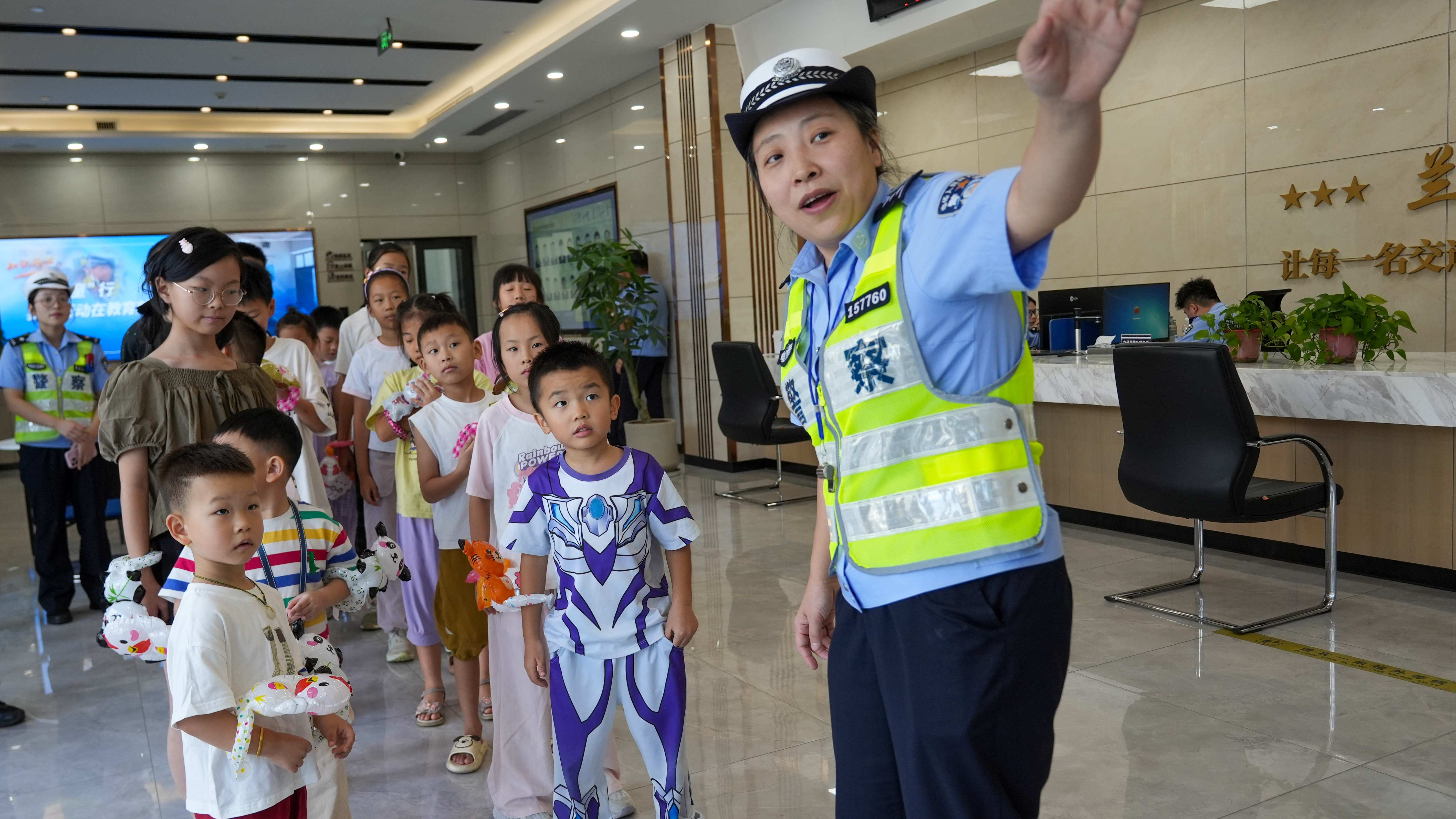 图为8月26日上午，浙江省兰溪市公安局交警大队民警向警娃介绍着办事大厅各个区域的功能。.JPG