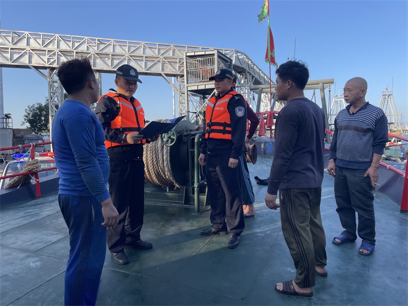图为港门海岸派出所民辅警在渔港码头对停靠船只进行安全检查.jpg
