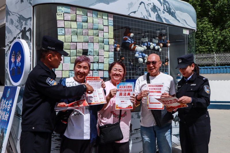 图为民警正在为群众讲解民法典,共创平安边境旅游,“典”亮美好生活 (2)(1).jpg