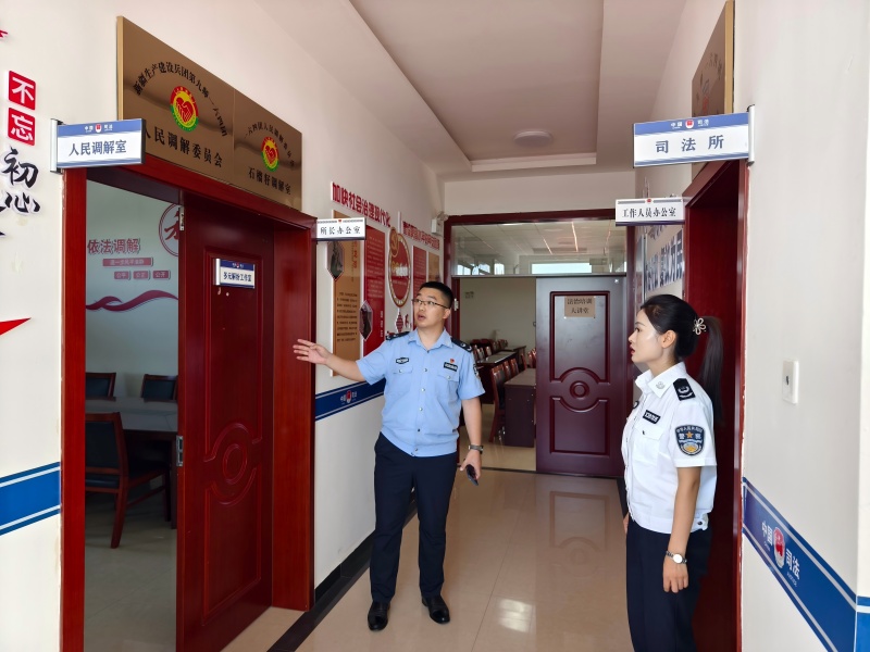 图为:一六四司法所工作人员向新城街道司法所工作人员介绍司法所(1).jpg
