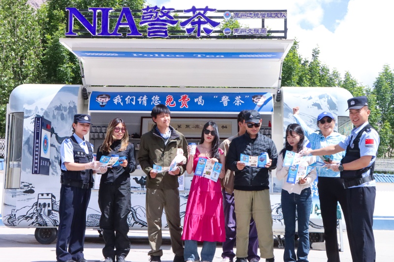 图为检查站民警在警茶服务点为旅客进行普法(1).jpg