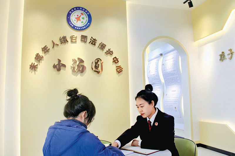 2022年11月3日，汤原县人民检察院检察官杜娟（右）在汤原县人民检察院“小汤圆”未成年人综合司法保护中心内，指导被救助人夏某馨（左）签订司法救助金申请表。（吴璇 摄).jpg