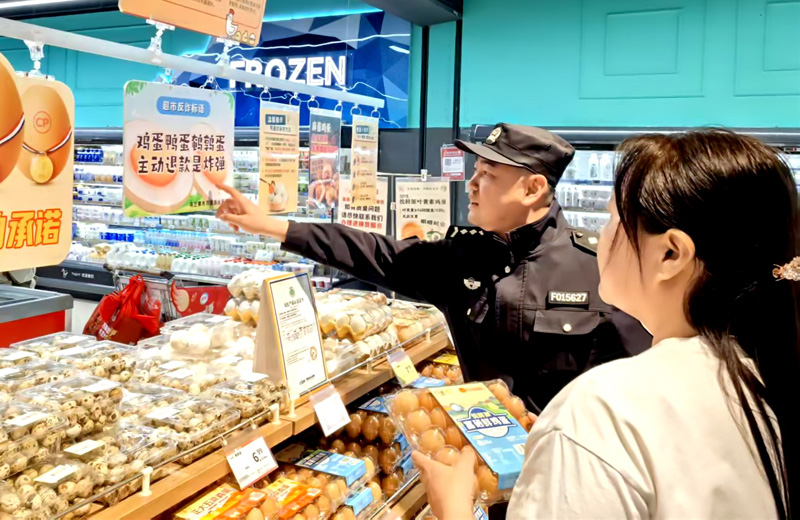 2025年5月，内蒙古呼和浩特市乌兰察布东路派出所民警在辖区超市悬挂反诈标语，市民驻足观看。.jpg