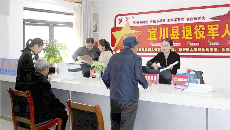 宜川县退役军人服务中心工作人员热情接待前来办理业务的退役军人。_proc.jpg