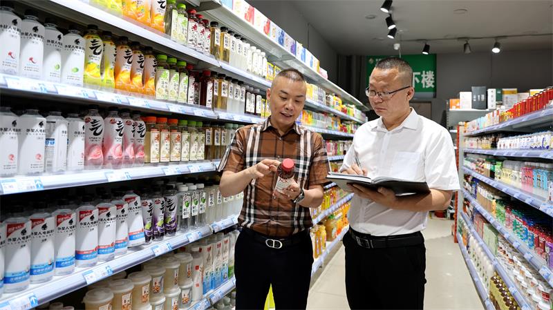 李战（左）在饮品专区检查。_proc.jpg