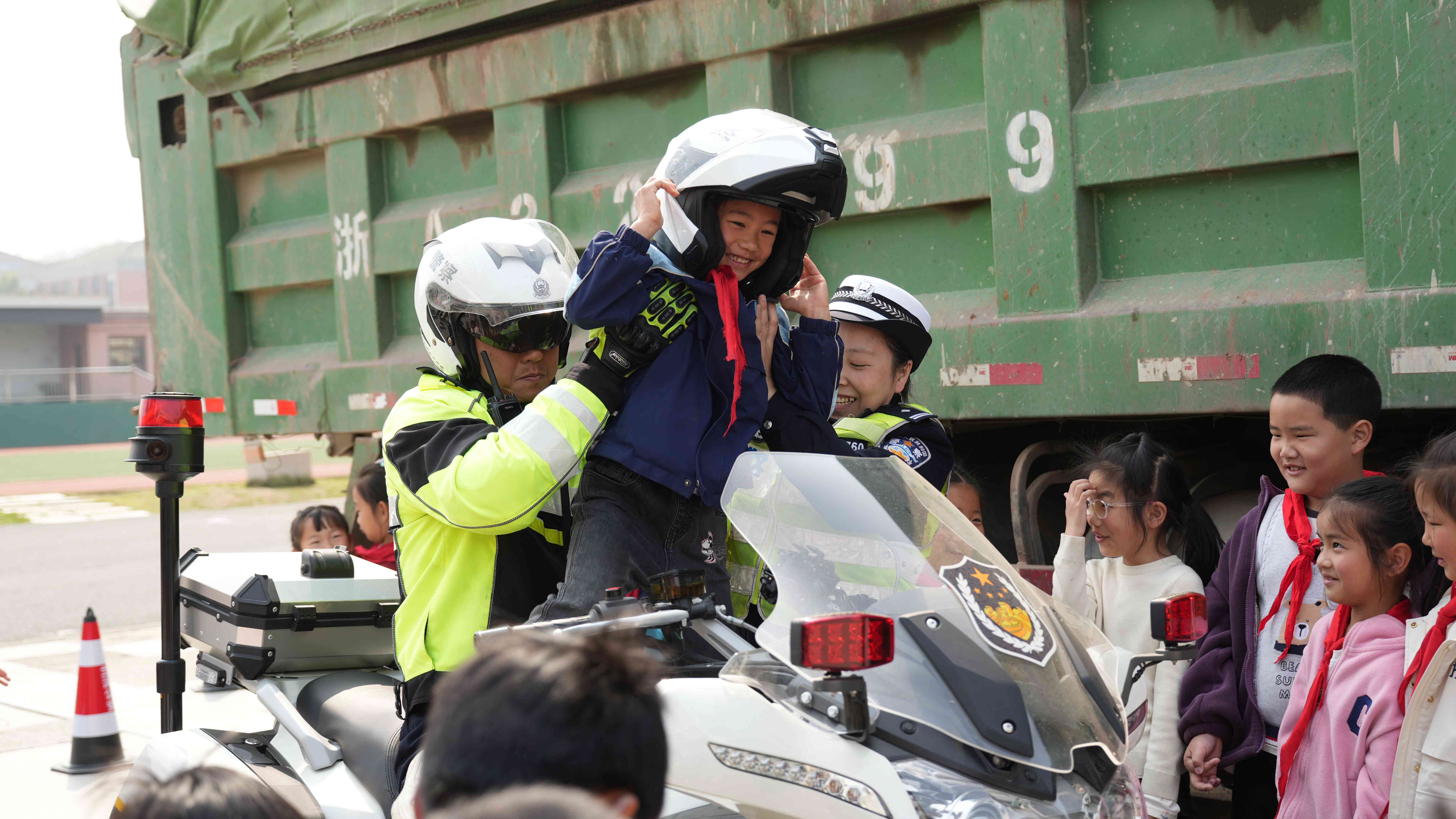 图为4月3日，浙江省兰溪市公安局交警大队铁骑队员抱起学生坐上摩托车，体验交警铁骑的日常工作。.jpg