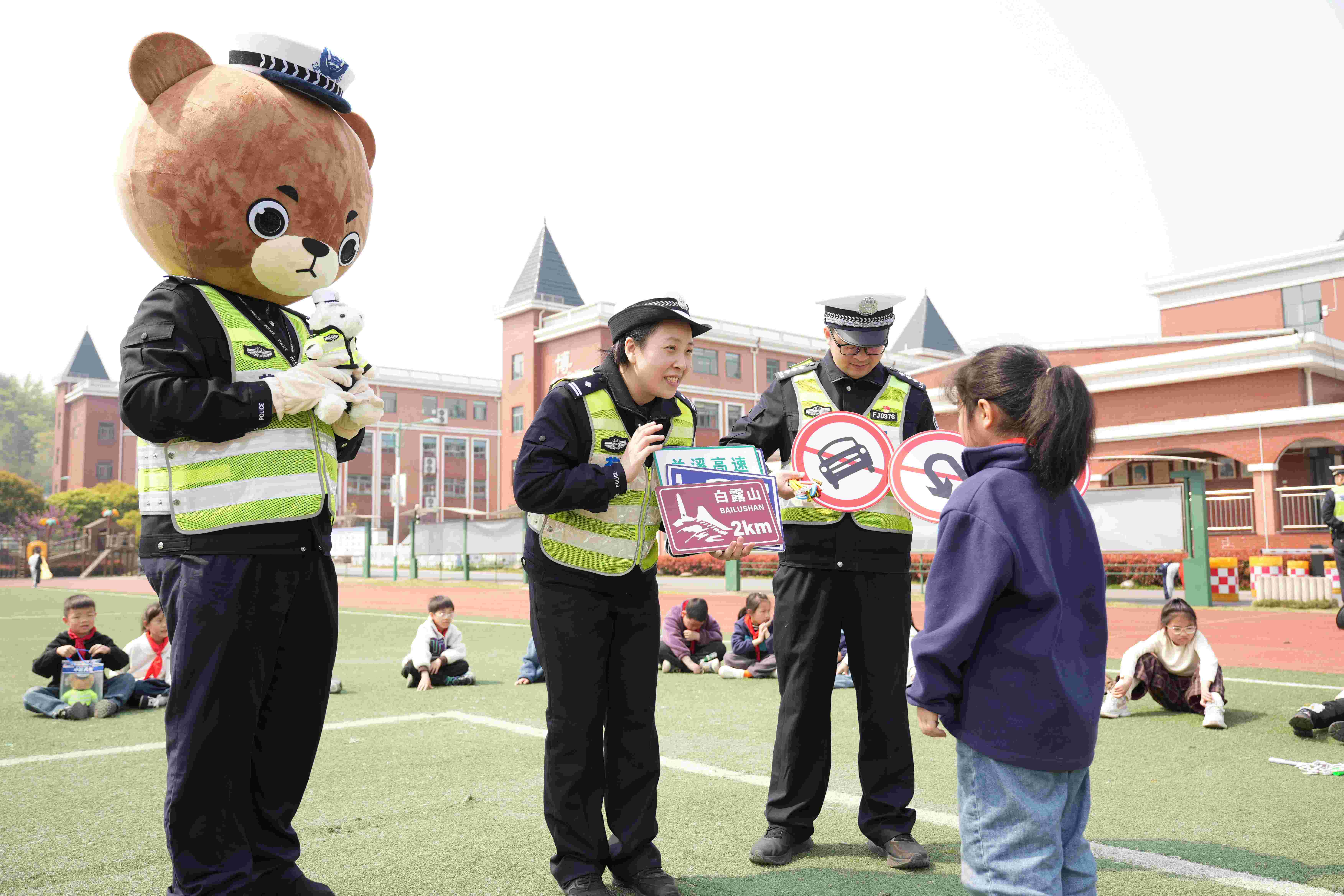 图为4月3日，浙江省兰溪市公安局交警大队民辅警携带”警熊小胖“开展有奖问答活动，为答对题的学生送上”交警小熊“教育学生们自觉遵守交通法规。.jpg