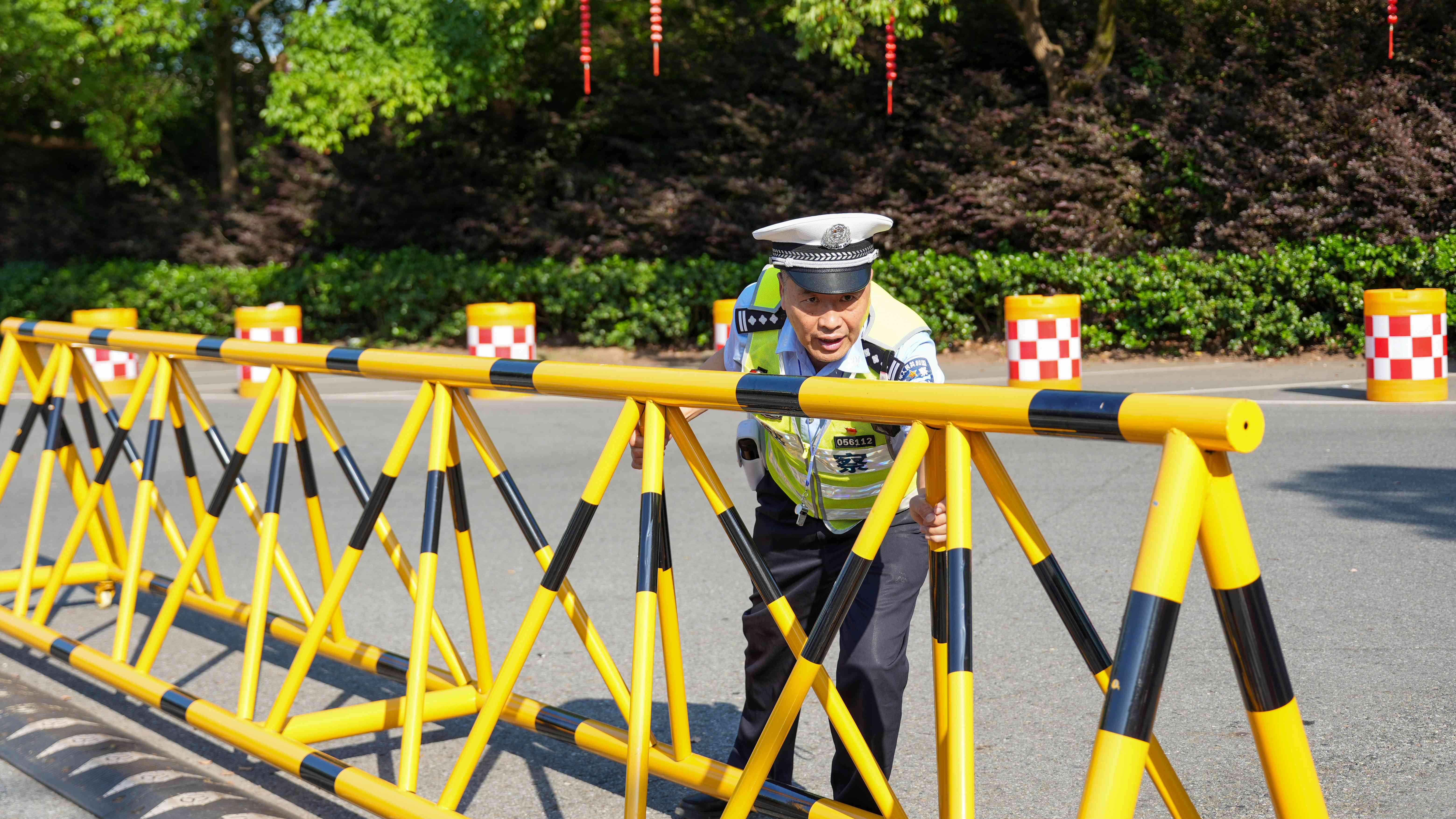 图为民警胡瑞双在兰溪市兰荫中学考点细致检查交安设施情况，确保高考万无一失。.jpg
