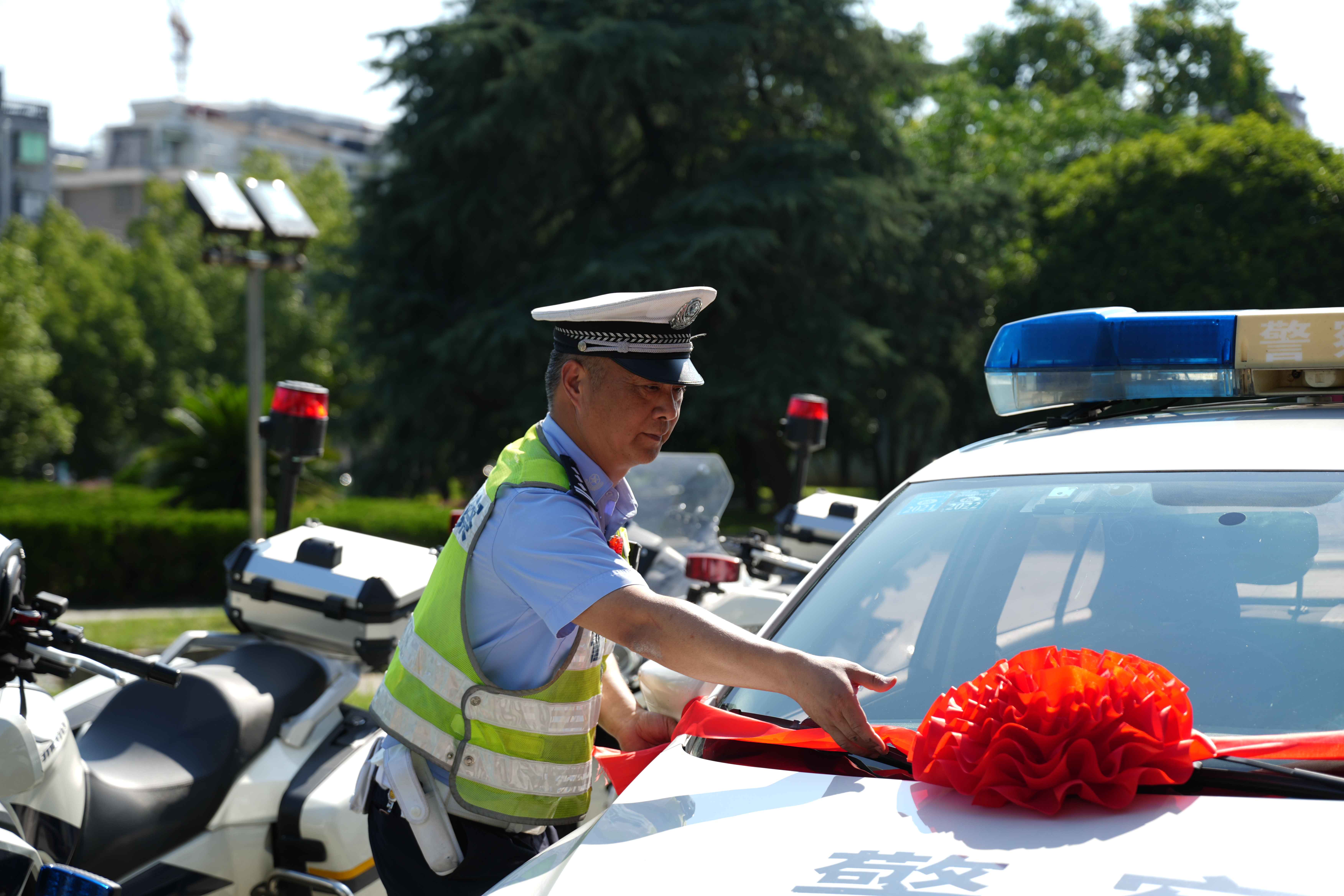 图兰溪交警在警车上挂起大红花，贴上护考标签，全力做好护考工作。.jpg