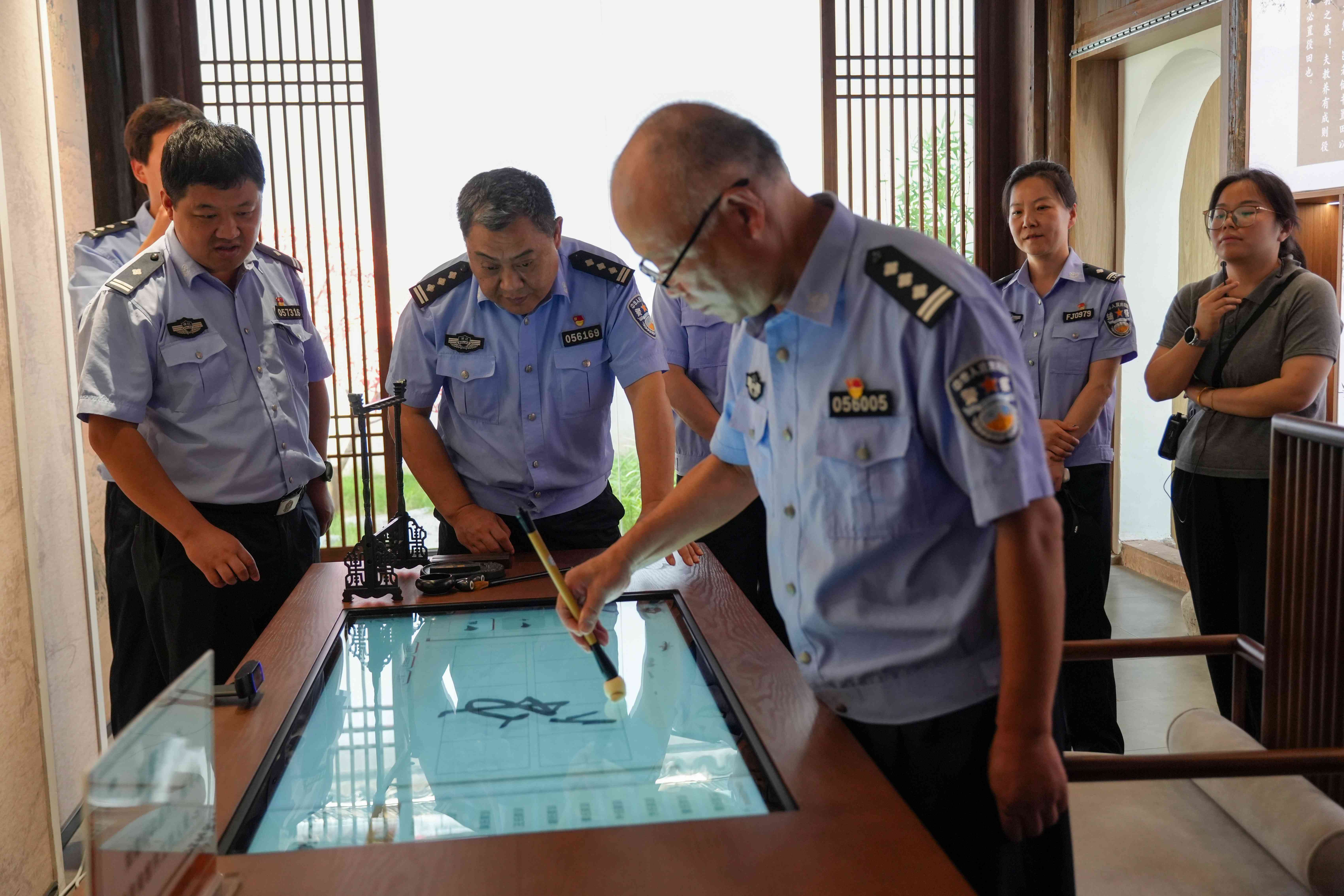 图为6月17日下午，浙江省兰溪市公安局交警大队分批组织党员民警走进家风家训馆，老民警在电子板上写下忠诚二字。.JPG