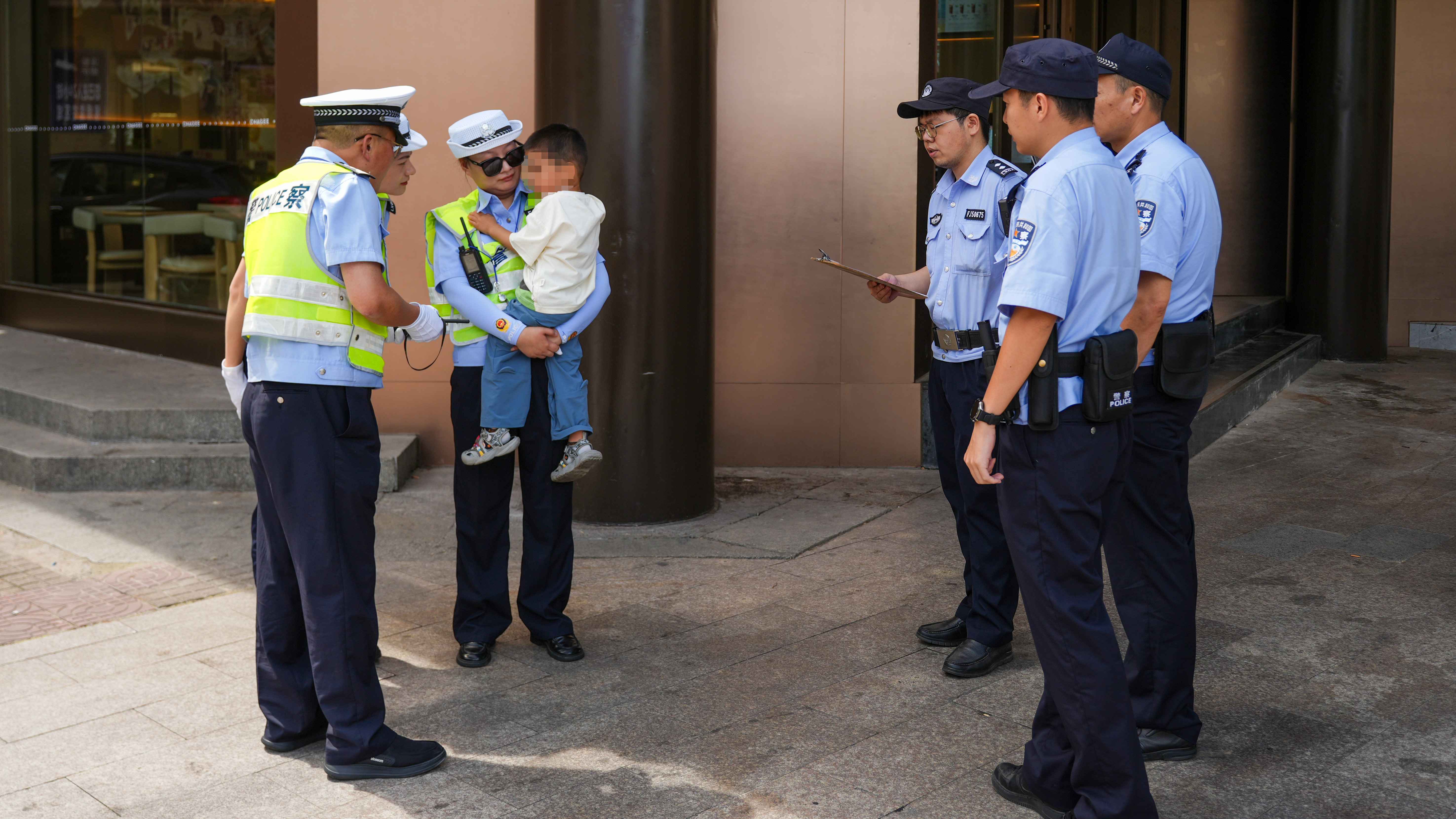 图为6月21日上午，浙江省兰溪市公安局交警大队民辅警在执勤时发现一名走失迷路的小男孩，暖心抱在怀里，细心照顾，并联合辖区云山派出所帮其寻找家人。.JPG