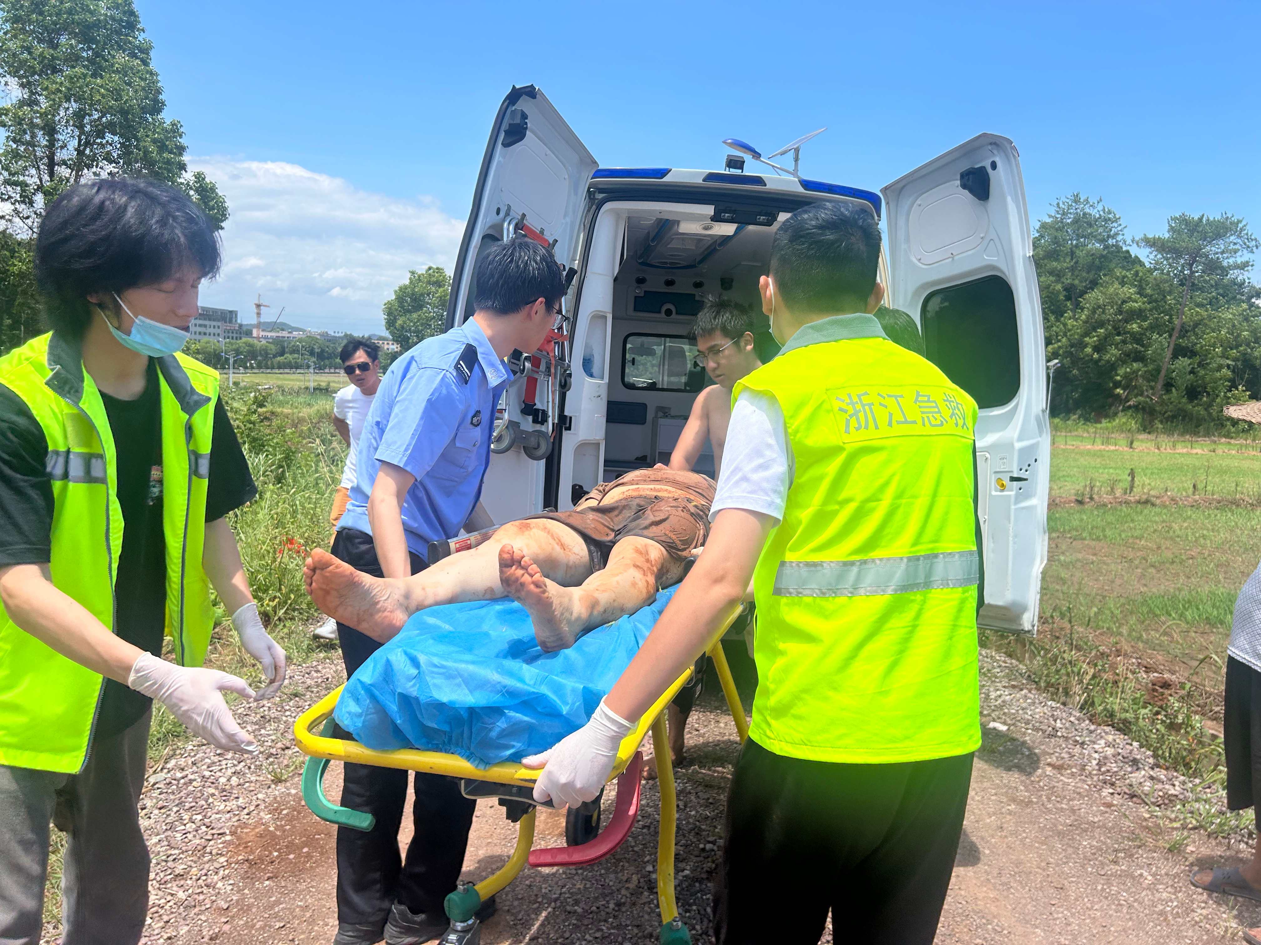 与医护人员合力将落水男子抬上救护车.jpg