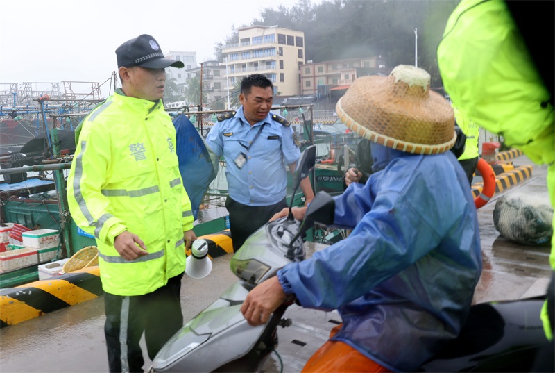 乌场海岸派出所和万宁综合行政执法局工作人员及时规劝在港口内停留的渔船民离港避风雨。代龙超摄.JPG