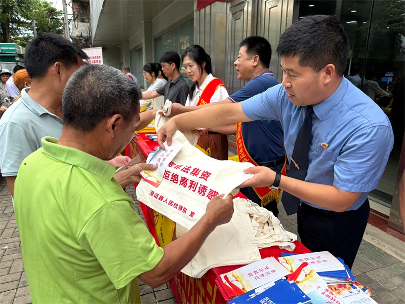检察干警为群众发放我院制作的普法宣传手册、法治周边袋子、雨伞等，并向群众普及相关法律知识，为群众答疑解惑。2.jpg
