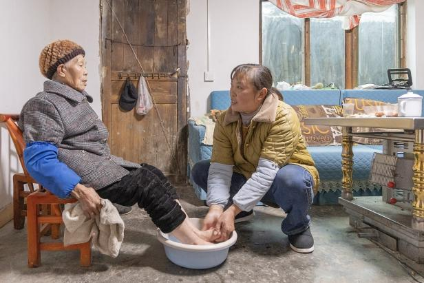 陈朝英（右）给婆婆洗脚。（赵恩峰 摄）.png