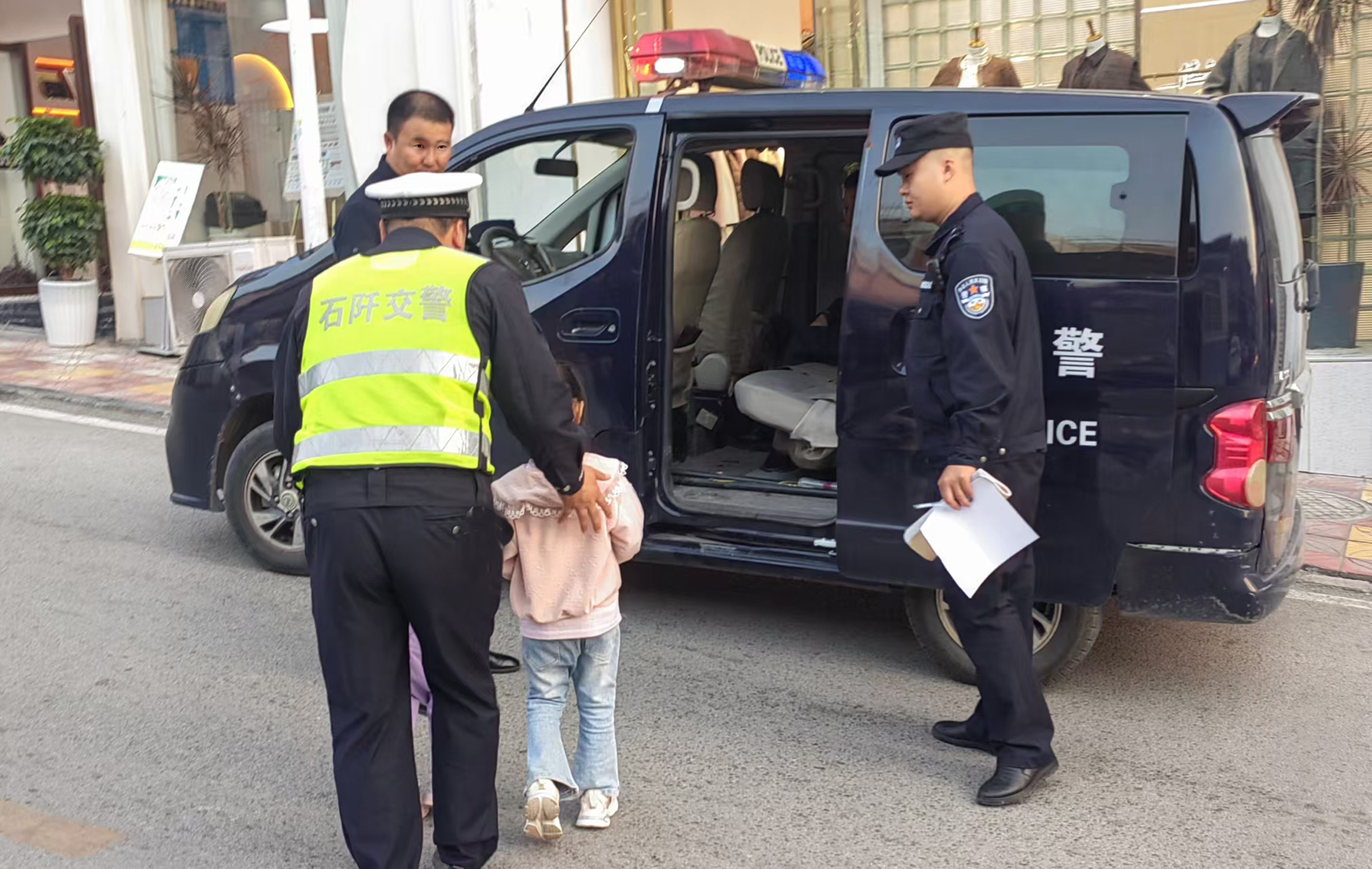 图2：民警辅警护送两名迷路小女孩坐警车.jpg