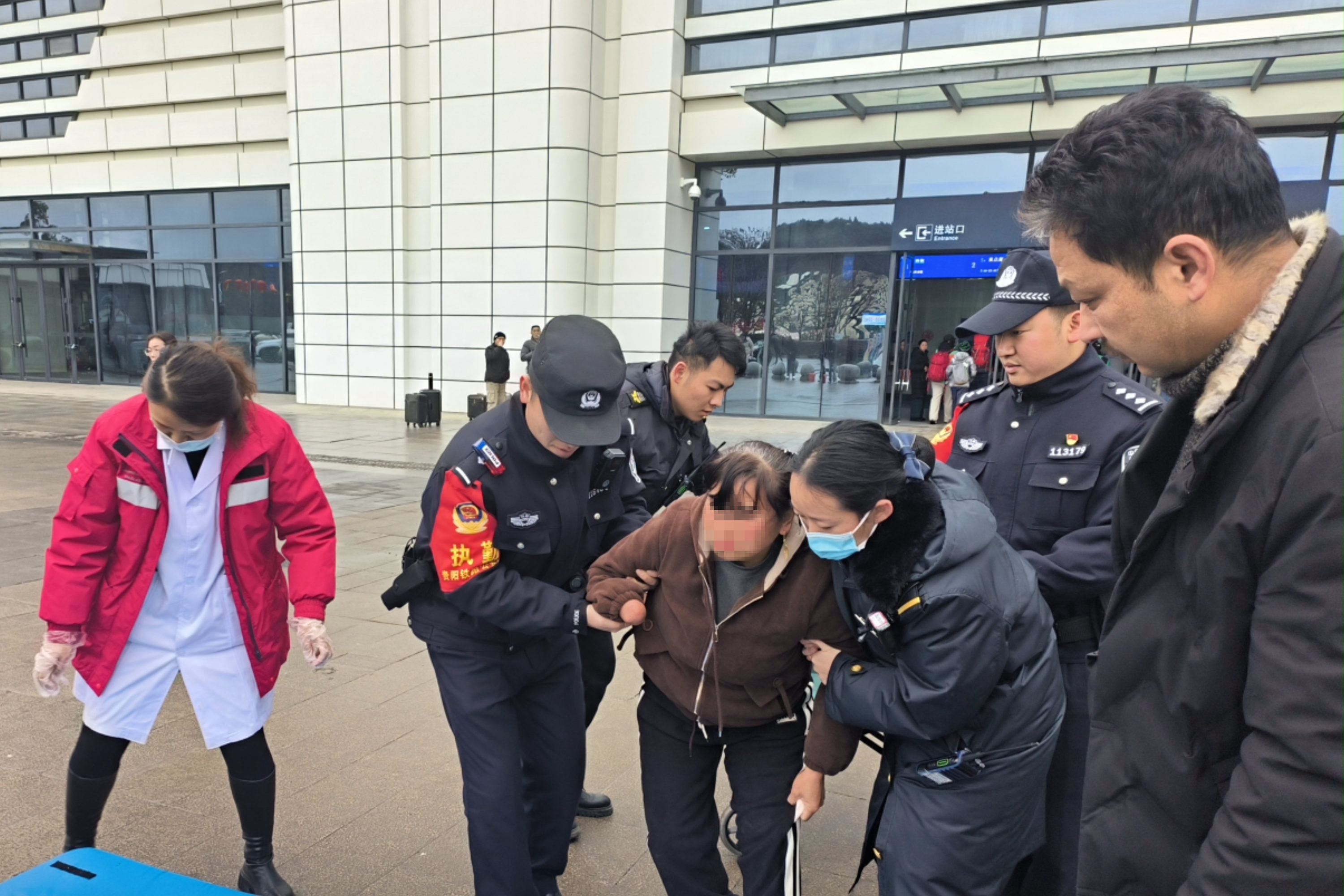 2 盘州站派出所民警为患病旅客联系120搀扶上担架。.jpg