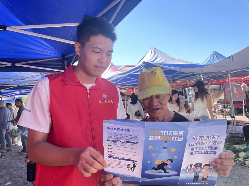 7月9日127团司法所组织返乡大学生在集市进行普法宣传1.JPG