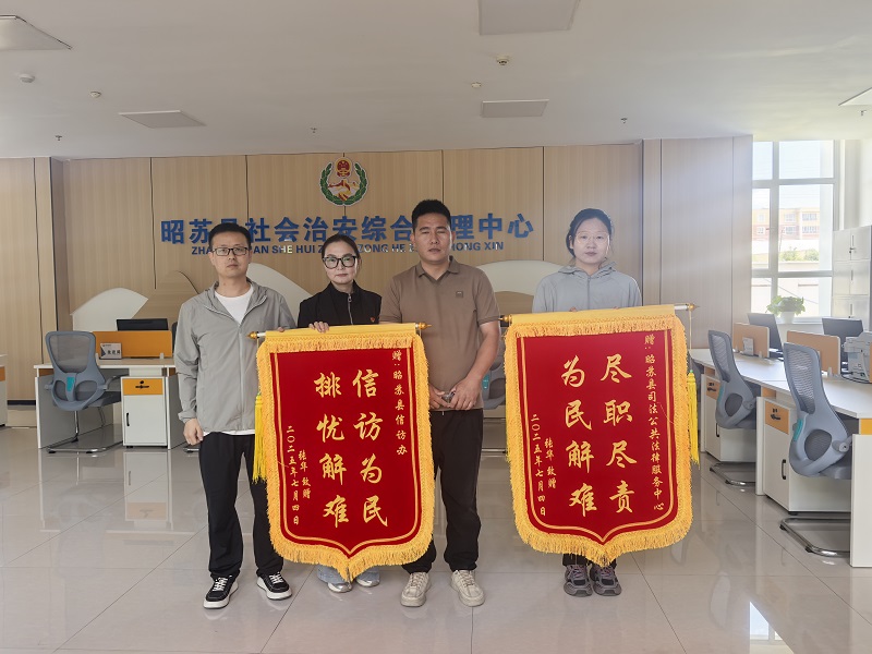图2：张某在昭苏县综治中心向昭苏县法律咨询专家送锦旗画面。通讯员周强摄.jpg