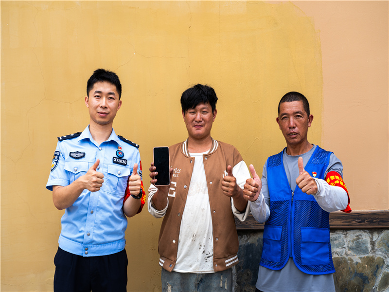 村民竖起大拇指，为义警和民警的闪电效率点赞。摄影者：洪永灿.jpg